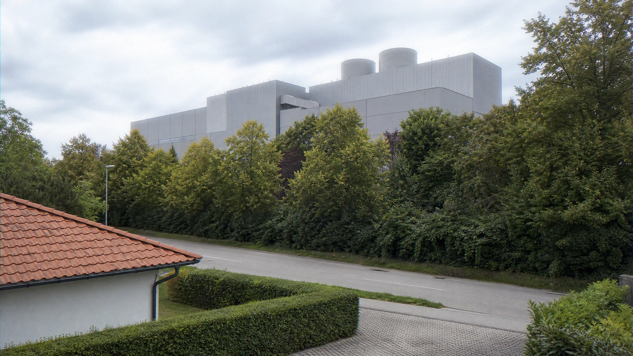 Photomontage aus Nachbarschaftsperspektive auf ein hyperscale Rechenzentrum hinter Landschaftspuffer